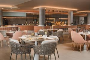 a restaurant with tables and chairs and a bar at Plus Fariones Suite Hotel in Puerto del Carmen