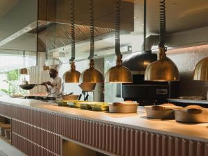 a chef preparing food in a restaurant kitchen at Plus Fariones Suite Hotel in Puerto del Carmen