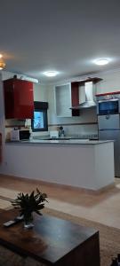 a kitchen with red and white cabinets and a table at Mirador de Usil in Mogro