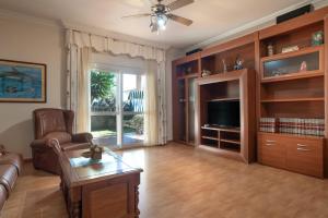 a living room with a couch and a tv at Chalet Los Delfines in Chiclana de la Frontera