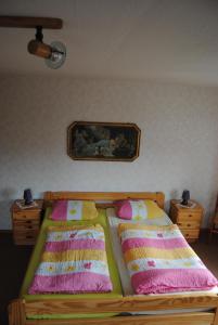 a bed with two pillows and a picture on the wall at Schule 8 in Windeby