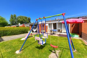 um parque infantil com um baloiço num quintal em Strandnahes Ferienhaus Mit Kinderspielplatz em Esens