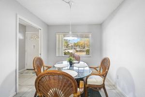 a dining room with a glass table and chairs at Seaside Bliss in Bradenton