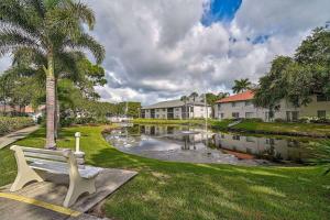 a park with a bench in front of a pond at Seaside Bliss in Bradenton