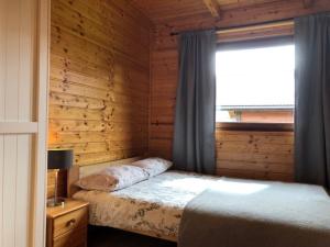 a bedroom with a bed and a window at Solina - Jezioro Solińskie - Domki in Wołkowyja +30 photos