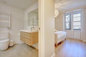 a bathroom with a sink and a toilet and a bed at Castillo by clabao in Pamplona