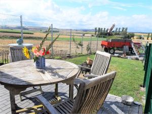 a wooden table with chairs and a table with flowers at Wellness Chalet in Gappenach