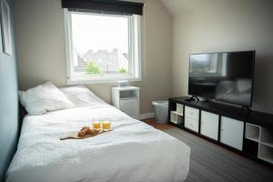 een slaapkamer met een bed met 2 glazen en een flatscreen-tv bij Spacious apt, Big roof terrace, Free parking in Stavanger