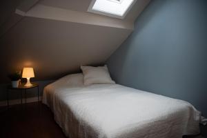 een slaapkamer met een wit bed en een raam bij Spacious apt, Big roof terrace, Free parking in Stavanger