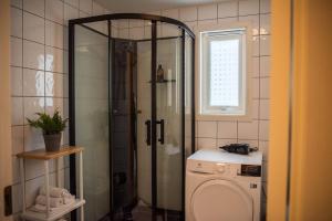een badkamer met douche en wasmachine bij Spacious apt, Big roof terrace, Free parking in Stavanger +31 foto's
