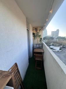 un balcone con tavolo e sedie su un edificio di Studio Cosy en bord de mer a La Grande-Motte Altre 8 foto