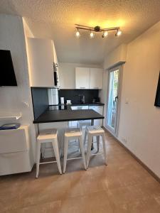 una cucina con tavolo e sgabelli in una stanza di Studio Cosy en bord de mer a La Grande-Motte