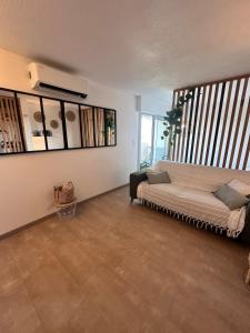 un soggiorno con letto e una grande finestra di Studio Cosy en bord de mer a La Grande-Motte