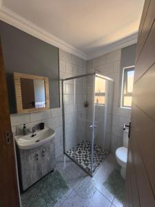 a bathroom with a shower and a sink and a toilet at Selina Guesthouse in Kempton Park +65 photos