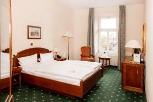 a hotel room with a bed and a window at Schlossparkhotel Schkopau in Schkopau +59 photos