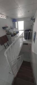 a white staircase in a kitchen with a stair case at Homestay 14 Tôn Đức Thắng in Phan Thiet +10 photos