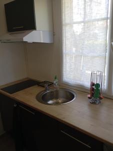 a kitchen counter with a sink and a window at Chambre d'Hôtes Les Macarons de Tata in Sainte-Eulalie