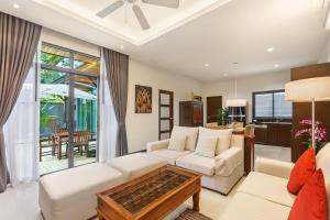 a living room with a couch and a table at Villa Anatta for your serene vacation in Ban Saiyuan (1)