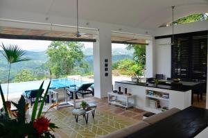 a living room with a view of a pool at Villa en Club Campestre Mesa de Yeguas in Anapoima
