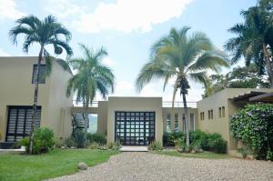 a house with palm trees in front of it at Villa en Club Campestre Mesa de Yeguas in Anapoima