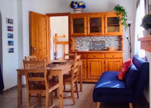 a dining room with a table and a blue couch at Case Natalia in Costa Rei +17 photos
