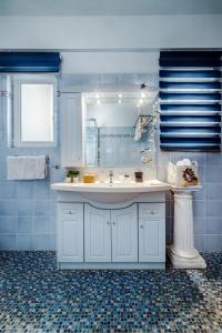 a blue bathroom with a sink and a mirror at Spacious Villa with pool 500m from the beach in Vari