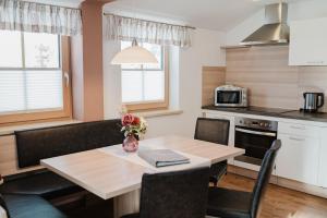a kitchen and dining room with a table and chairs at Pension Bacherhof in Mariapfarr