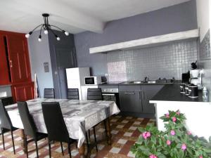 a kitchen with a table and chairs in a kitchen at Le gîte de Buneville in Buneville