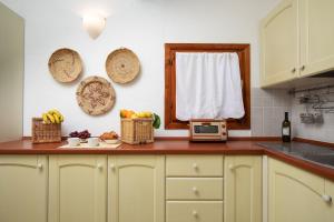 una encimera con cestas de fruta y una ventana en Homey Experience - Attic Panorama, en La Maddalena