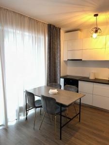 Una cocina con una mesa y sillas en una habitación. en Nor Apartament, en Bucarest