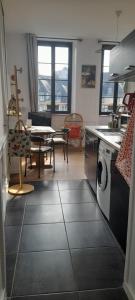a kitchen and dining room with a table and a washer at Le secret d'Oscar & la fantaisie de Jean in Morlaix