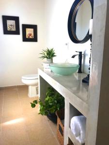 a bathroom with a bowl sink and a toilet at Casa Botanica in Lo de Marcos +65 photos