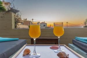 two glasses of orange juice on a tray on a table at Casa Anthea 3 bedroom apartment with Garden in Kounoupidhianá