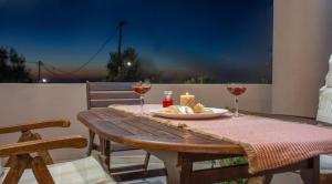 a wooden table with wine glasses and a plate of food at Casa Anthea 3 bedroom apartment with Garden in Kounoupidhianá