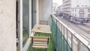 una mesa y sillas en un balcón con una calle de la ciudad en Le Reflet Secret - Hypercentre - Balnéo, en Troyes