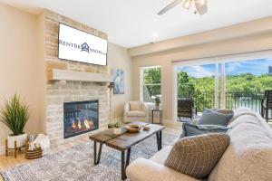 a living room with a couch and a fireplace at Lake Taneycomo Views-Near Branson Landing-Cmty Outdoor Pool-Free Tickets-Elevator! in Branson