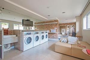 a kitchen with two washing machines and a couch at Studio Moderno Santo Amaro - Perto do Consulado, Transamerica, CGH, Autódromo e Vibra São Paulo in Sao Paulo