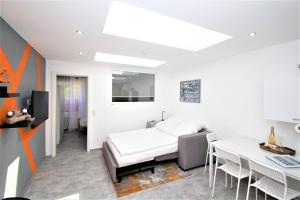 a white room with a bed and a table at Ferienwohnung Glücks-Burg "Stern" in Glücksburg