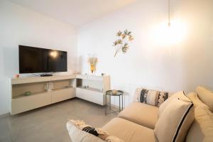 a living room with a couch and a flat screen tv at Opuntia Home in Monopoli