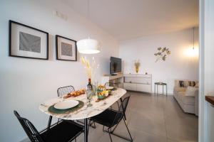 a dining room and living room with a table and chairs at Opuntia Home in Monopoli