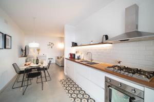 a kitchen with a table and a kitchen with white walls at Opuntia Home in Monopoli