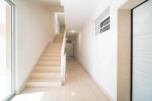 a staircase in a house with white walls and white floors at Opuntia Home in Monopoli