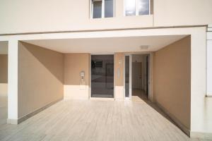 an empty hallway of a building with an open door at Opuntia Home in Monopoli