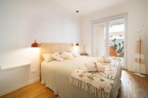 a white bedroom with a bed and a window at Opuntia Home in Monopoli