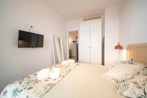 a bedroom with a bed with a tv on the wall at Opuntia Home in Monopoli