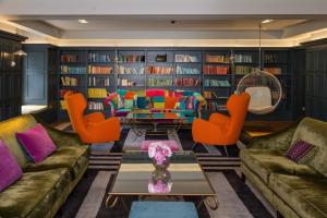 a living room with couches and orange chairs at Rudding Park in Harrogate