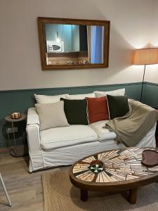 a living room with a white couch and a mirror at Charmant appartement proche centre-ville in Vannes +11 photos