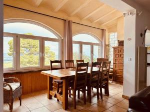 a dining room with a table and chairs and windows at Casa Mas Tomasi Pals in Pals +17 photos