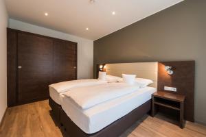 a bedroom with two beds and a wooden headboard at apart N serviced apartments in Nuremberg