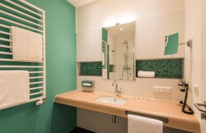 a bathroom with a sink and a mirror at apart N serviced apartments in Nuremberg +18 photos